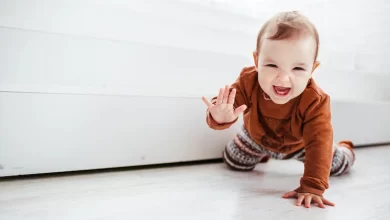 happy child orange sweater plays with feather floor 8353 185